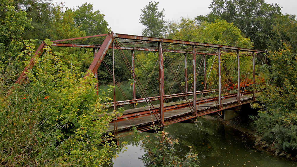  This abandoned bridge, located in Tully Township, crosses the Olentangy River and is visible from Morral-Kirkpatrick Road East. It dates to 1876 and was constructed by the Wrought Iron Bridge Company.